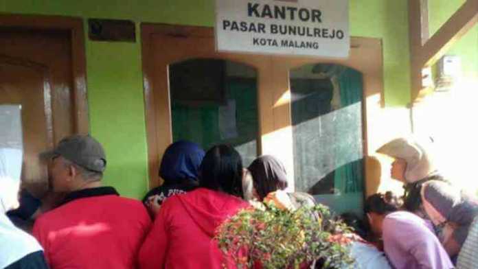 Warga penasaran dengan sosok MD di Kantor Pasar Bunulrejo. (istimewa)