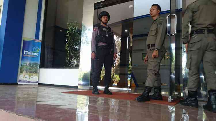 Petugas kepolisian saat menjaga Kantor DPKPCK Kabupaten Malang. (Toski D)