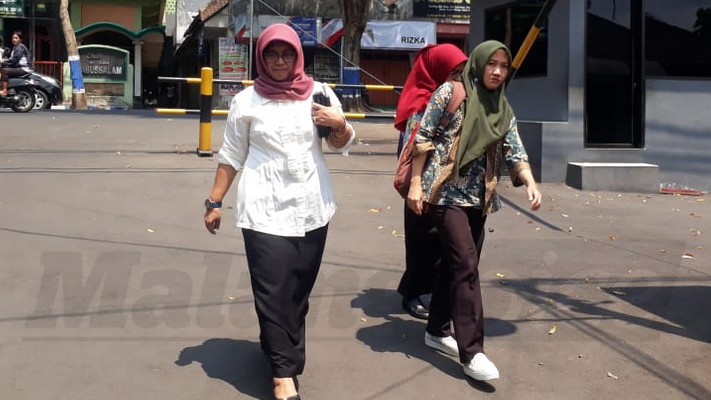 Tridiyah Maestuti saat datang di Polres Malang bersama Dwi July kasubag keuangan BLH dan Sophia L bendhara BLH. (Toski D)