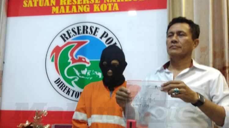 Kasat Reskoba Polres Malang Kota AKP Syamsul Hidayat membawa barang bukti sabu-sabu. (deny rahmawan)