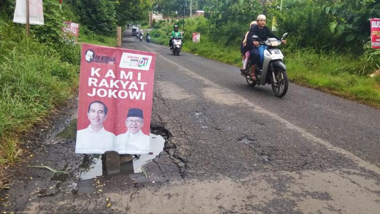 Poster Paslon Jokowi – Ma’ruf Dipasang di Tengah Jalan Berlubang di Kota Malang