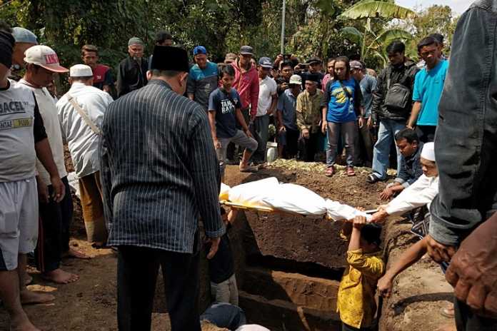 Masyarakat beserta keluarga mengebumikan seluruh jenazah korban kebakaran rumah di Taman Pemakaman Umum (TPU) Dusun Junwatu, dekat Krematorium Desa Junrejo, Kota Batu, Rabu (24/7). (Foto: Ayun/MVoice)