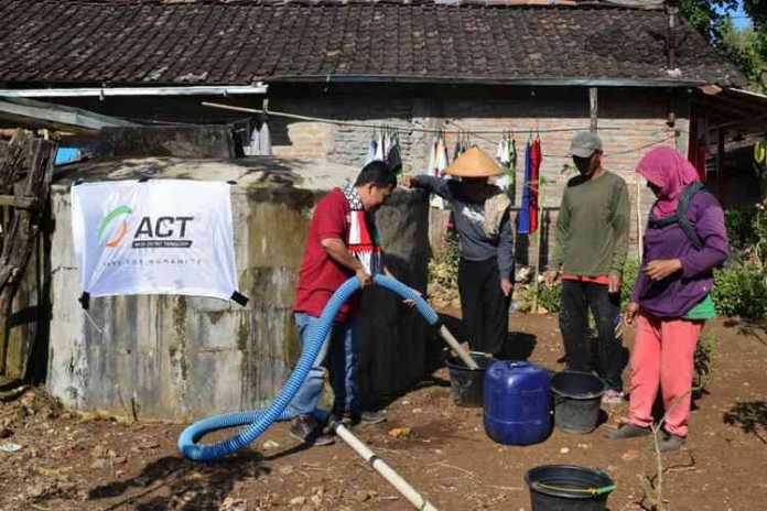 Tim ACT memberi bantuan air bersih kepada warga.