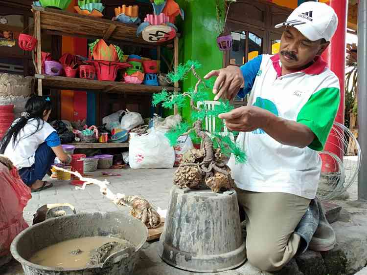 Rudi Eko Prasetyo warga Desa Torongrejo, Kota Batu tampak membuat replika tanaman hias Bonsai, Kamis (18/7). (Foto: Ayun/MVoice)