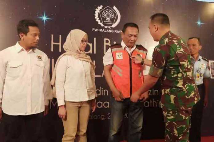 Aster Divisi 2 Kostrad Singosari Kolonel (Inf) Erwin saat memakaikan secara simbolis rompi rescue kepada anggota PWI Malang Rescue.
