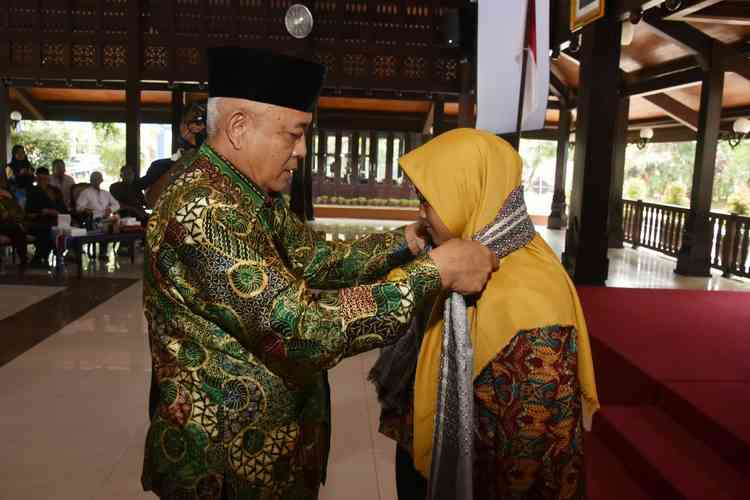 Plt. Bupati Malang, HM Sanusi saat mengalungkan sorban secara simbolis kepada perwakilan peserta. (Istimewa/Humas)