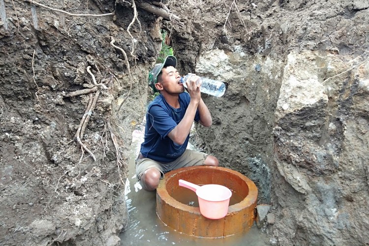 Salah satu warga saat meminum sumber air panas Nyi Sindu yang terletak di Desa Sumberejo, Kota Batu (Foto: Ayun/MVoice)