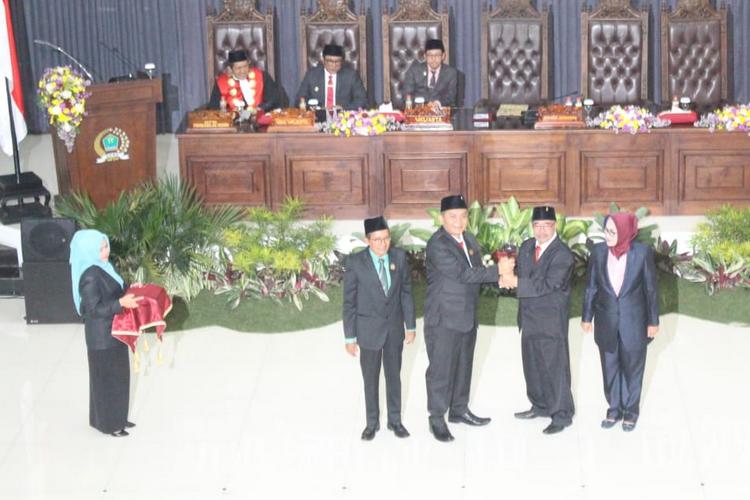 Mantan Ketua DPRD Kota Malang Bambang Heri Susanto menyerahkan palu sidang kepada Ketua DPRD Kota Malang Sementara I Made Rian Diana, Sabtu (24/8). (Aziz Ramadani MVoice)