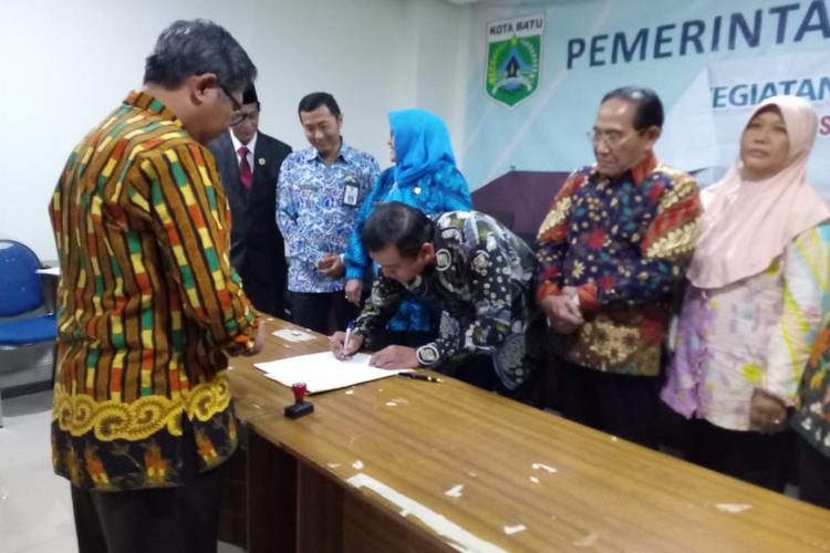 Ketua Koalisi Kependudukan Kota Batu, Didik Supriyanto saat menandatangani SK keputusan di Balai Kota Among Tani (istimewa)