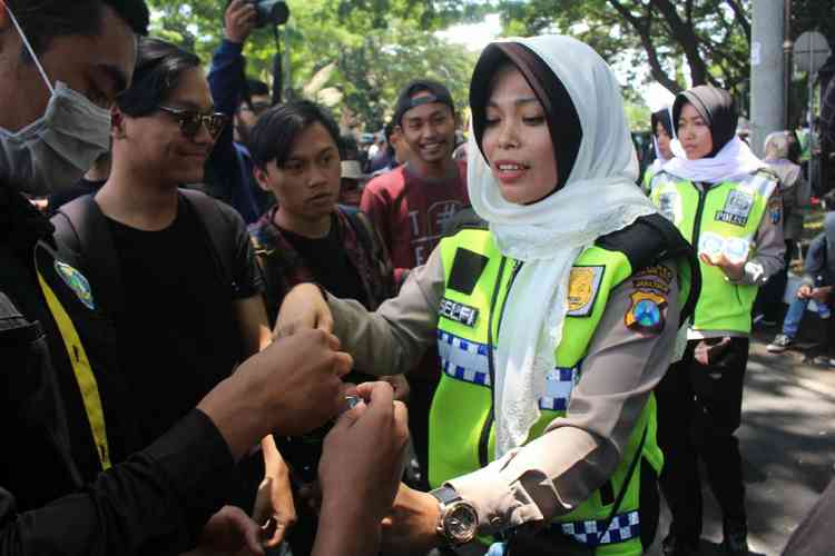 Polwan saat bagikan permen kepada demonstran di depan gedung DPRD Kota Malang, Senin (30/9). (Aziz Ramadani MVoice)