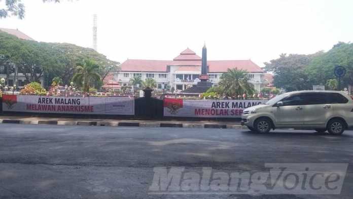 Penampakan aksi spanduk penggalangan tanda tangan di pagar Monumen Tugu Kota Malang.(Aziz Ramadani MVoice)