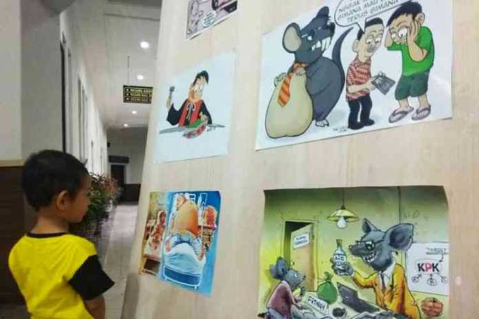 Suasana pameran Saweran Kartun bertema anti korupsi di lobi Balai Kota Malang, Jumat (1/11). (Aziz Ramadani MVoice)