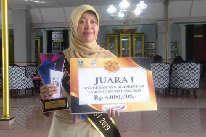 Nuning Nur Laila saat menunjukan penghargaan Anugerah ASN Berprestasi 2019. (Toski D)
