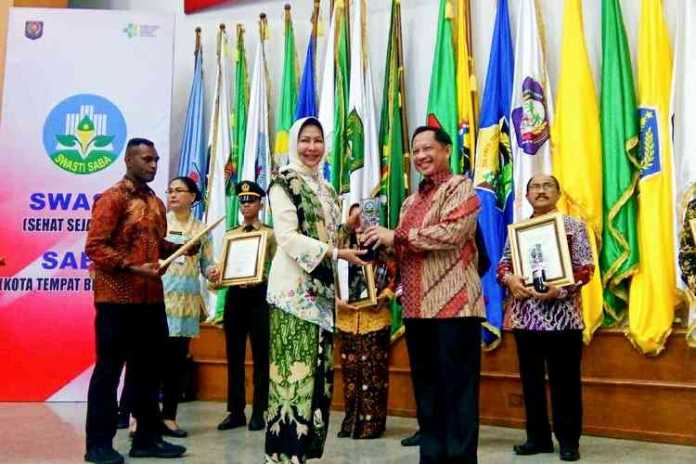 Wali Kota Batu, Dewanti Rumpoko saat menerima penghargaan Anugerah Swasti Saba Wiwerda dari Mendagri Tito Karnavian. (Humas for MVoice)