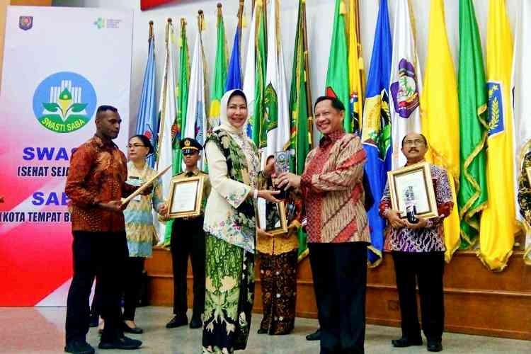 Wali Kota Batu, Dewanti Rumpoko saat menerima penghargaan Anugerah Swasti Saba Wiwerda dari Mendagri Tito Karnavian. (Humas for MVoice)