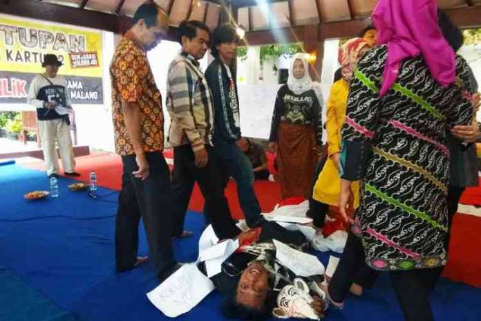 Sekda Kota Malang, Wasto dan beberapa pejabat OPD menginjak sosok tikus yang diperankan seniman pada penutupan pameran kartun di Balai Kota Malang, Sabtu (2/11). (Aziz Ramadani MVoice)