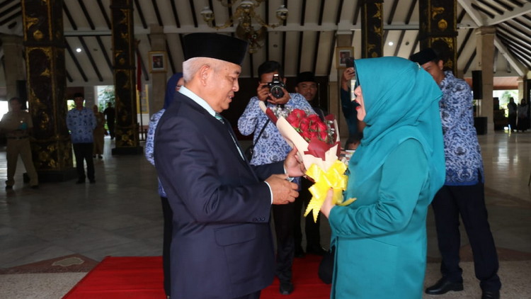 Bupati Malang HM Sanusi saat memberikan Bucket bunga ke Hj. Anis Zaida. (Toski D).
