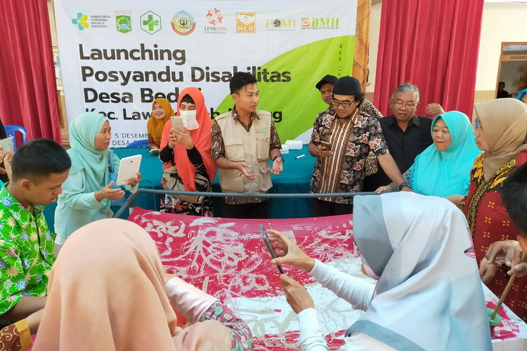 Instruktur Batik Ciprat BMH (tengah)  Menjelaskan proses membuat batik ciprat kepada para disabilitas dan  pendamping posyandu disabilitas di desa Bedali Lawang Malang , Kamis (5/12).