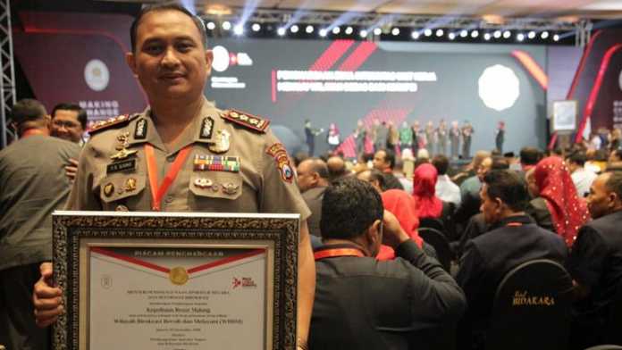 Kapolres Malang AKBP Yade Setiawan Ujung, saat menunjukkan piagam penghargaan WBBM. (Istimewa)