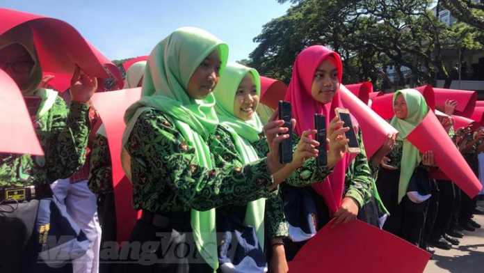 Ribuan pelajar pecahkan rekor MURI baca bersama buku digital lewat gawai di depan Balai Kota Malang, Kamis (12/12). (Aziz Ramadani MVoice)