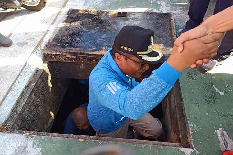 Wakil Wali Kota Malang Sofyan Edi Jarwoko masuk ke drainase di Jalan Letjen Sutoyo, Jumat (21/2). (Humas Pemkot Malang)