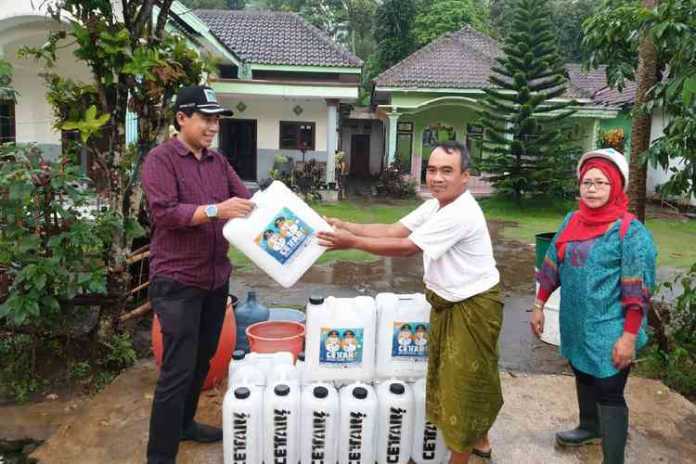 Direktur Perumda Tugu Tirta Kota Malang, M.Nor Muhlas, saat menyalurkan bantuan ke warga terdampak. (Istimewa)