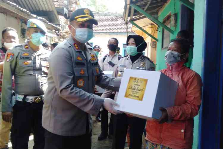 Kapolres Malang AKBP Hendri Umar saat memberikan bantuan paket sembako. (Toski D).