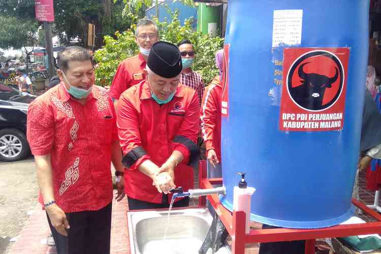 Ketua Bamusi DPC PDI Perjuangan Kabupaten Malang, HM Sanusi, saat cuci tangan di wastafel portabel di Pasar Kepanjen. (Toski D).