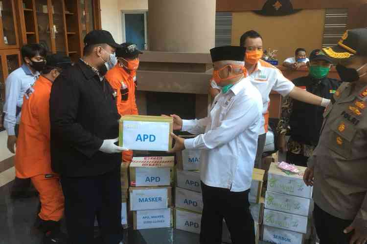 Manajer Oprasional BMH Gerai Malang Sony Abdul Karim saat menyerahkan bantuan APD yang diterima langsung oleh Bupati Malang HM Sanusi. (Toski D)
