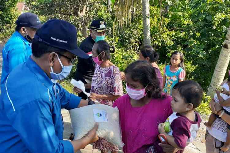 Dirut Perumda Tirta Kanjuruhan Kabupaten Malang Syamsul Hadi saat memberikan bantuan sembako kepada masyarakat yang terdampak Covid-19. (Istimewa).