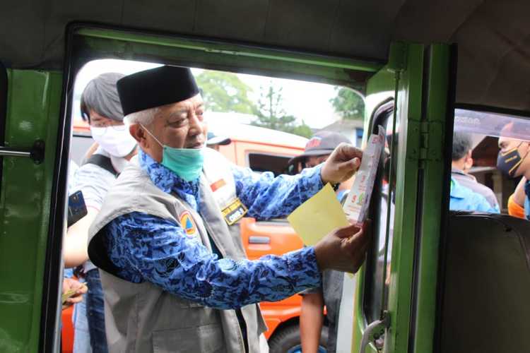 Bupati Malang HM Sanusi saat menempelkan stiker secara simbolis ajakan Bersama Lawan Covid-19 dan Sukseskan PSBB dibeberapa angkutan umum. (Istimewa).